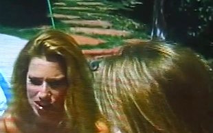 Two bombshell topless blondes are making out with a dildo near a pool